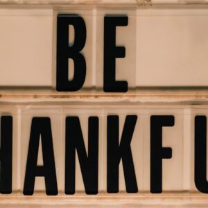 Black letters spell out "be thankful" on a sign.